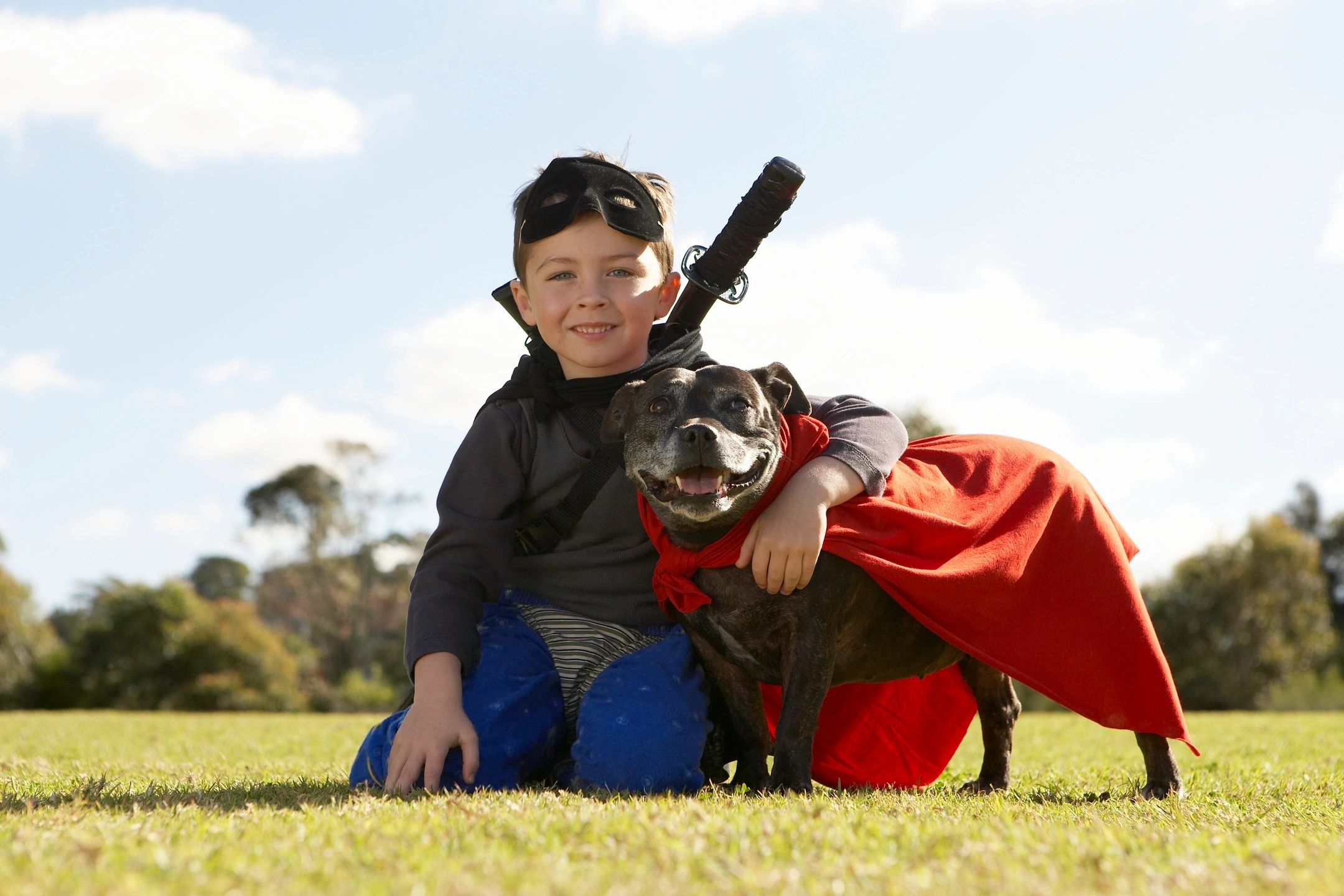 Young boy and dog dressed as super heroes